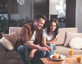 Cheerful couple tasting fresh fruits and berries in living room