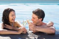 Cheerful couple toasting champagne in swimming pool Royalty Free Stock Photo