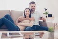 Cheerful couple is watching tv together and having fun. They are Royalty Free Stock Photo
