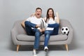 Cheerful couple woman man football fans cheer up support favorite team with soccer ball clenching fist, showing tongue