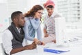 Cheerful coworkers working together with computer