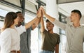 Cheerful creative business team standing in office and giving high five while celebrating a win. Diverse business people Royalty Free Stock Photo