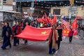 Cheerful crowd of people holding flags in the air while celebrating outdoors