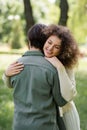 cheerful and curly woman in cardigan Royalty Free Stock Photo