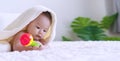 Cute baby lying on bed with toy under white blanket looking at something. Innocence baby crawling on white bed with towel Royalty Free Stock Photo