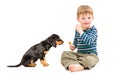Cheerful cute boy with candy in hands sitting with his puppy Royalty Free Stock Photo