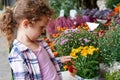 Cheerful cute child girl with curly hair choosing yellow flowers in the flower shop Royalty Free Stock Photo