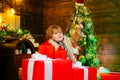 Cheerful cute child opening a Christmas present. Happy child with Christmas gift box. Winter kid. Funny kid holding Royalty Free Stock Photo