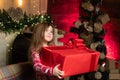 Cheerful cute child opening a Christmas present. Little girl presents her gift with a thankful face. The Real Joy of Royalty Free Stock Photo