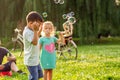 Cheerful children chase bubbles in nature Royalty Free Stock Photo