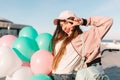 Cheerful cute girl with dark hair gladly posing with peace sign at the ocean pier after event. Young brunette woman with