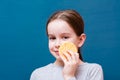 Cheerful cute girl washing her face with a cosmetic sponge on a blue background. Child Hygiene Concept Royalty Free Stock Photo