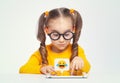 Cheerful cute little girl with glasses using tablet computer on white background. Social media concept. Royalty Free Stock Photo