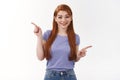 Cheerful, cute redhead caucasian female student in purple t-shirt sharing two choices, suggest variants, have few