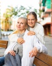 Cheerful teen girl and her mother embracing on city street Royalty Free Stock Photo