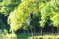 Cheerful cute young boy in blue t shirt and orange helmet in adventure rope park at sunny summer day. Active lifestyle, sport Royalty Free Stock Photo