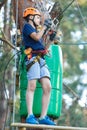 Cheerful cute young boy in blue t shirt and orange helmet in adventure rope park at sunny summer day. Active lifestyle, sport Royalty Free Stock Photo