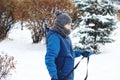 Cheerful cute young boy in  hat , scarf and blue jacket holds tube on snow, has fun, smiles. Teenager on sledding Royalty Free Stock Photo