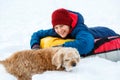 Cheerful cute young boy in orange hat red scarf and blue jacket holds tube on snow, has fun, smiles. Teenager on sledding Royalty Free Stock Photo