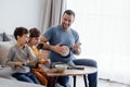 Cheerful dad having fun with two little kids in living room at home Royalty Free Stock Photo