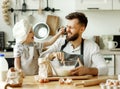 Cheerful dad and kid having fun while cooking together