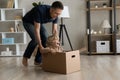 Cheerful dad shifting cardboard box with happy little son inside