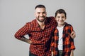 Cheerful daddy and son in stylish outfits