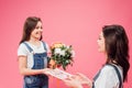 Cheerful daughter giving card and flowers to mom on mothers day isolated