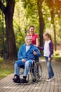 Cheerful daughter and grandchildren visiting disabled father in