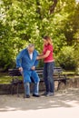 Cheerful daughter helping disabled father in park