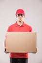 Cheerful delivery man happy young courier holding a cardboard box and smiling Royalty Free Stock Photo