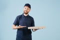 Cheerful delivery man in uniform is holding cardboard pizza box Royalty Free Stock Photo