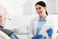 cheerful dentist with tablet in hands