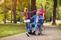 cheerful disabled grandfather in wheelchair welcoming his granddaughter. Royalty Free Stock Photo