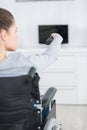 Cheerful disabled senior woman watching television in living room Royalty Free Stock Photo