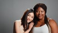 Cheerful diverse models laughing and hugging in studio