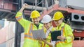 Cheerful dock workers with the supervisor, recording data online using a laptop at a warehouse Royalty Free Stock Photo