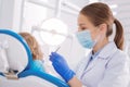 Cheerful doctor looking at the condition of teeth and feeling glad