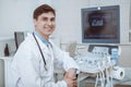 Cheerful doctor using ultrasound scanner at work Royalty Free Stock Photo