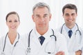 Cheerful doctors posing together crossing arms