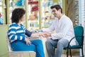 Cheerful druggist and woman customer in pharmacy