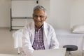 Cheerful elder Indian doctor man wearing white coat and glasses Royalty Free Stock Photo