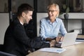 Cheerful elder professional woman talking to younger coworker man Royalty Free Stock Photo