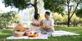 Cheerful elderly couple asian wear casual clothes sitting in the park having a party together Royalty Free Stock Photo