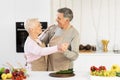 Cheerful Elderly Couple Dancing In Kitchen Having Fun At Home Royalty Free Stock Photo