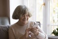 Cheerful elderly great grandma woman using mobile phone at home Royalty Free Stock Photo