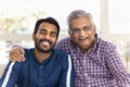 Cheerful elderly Indian father hugging young adult son Royalty Free Stock Photo