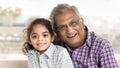 Cheerful elderly Indian great grandfather and grandkid girl sitting close Royalty Free Stock Photo