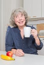 Cheerful elderly lady with mug