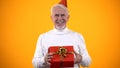 Cheerful elderly man holding gift box, present from close people, happiness